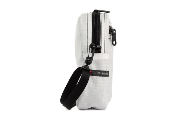 A profile shot of an Everyday Cubelet in Tahoma Halcyon (white with a white grid) with a front zipper.